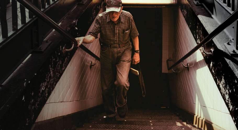 man-in-collared-shirt-and-gray-pants-walking-on-stairs-859209